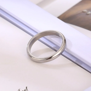 Close-up of a minimalist silver stainless steel ring with a high-polished smooth surface