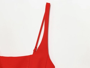 Détail de la robe rouge sans manches montrant la fine bretelle réglable et le tissu tissé