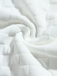 Macro shot of white checkered jacquard fabric texture on long sleeve slim fit men's shirt