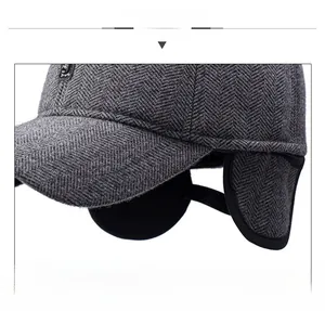 Detailed macro view of dark grey herringbone wool texture and plush earflaps on winter cap
