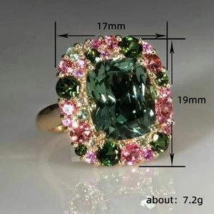 Lujoso anillo cóctel con cristal verde esmeralda y halo de colores en banda dorada