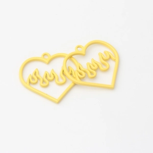 Detailed view of yellow heart-shaped pendants with flame design for DIY jewelry making