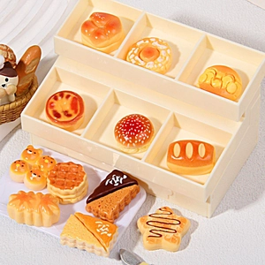 Assorted miniature resin bread and pastry charms displayed on a professional tiny bakery rack
