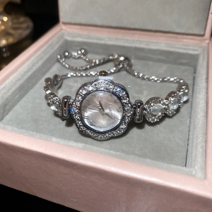 Detail of silver quartz watch with floral crystal bezel on a pink jewelry box