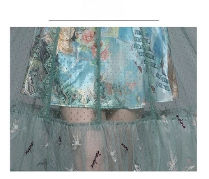 Detail of embroidered tulle fabric with sequined birds and vintage floral patterns