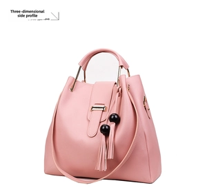 Side view of pink crossbody bag with beaded tassel and structured three-piece design