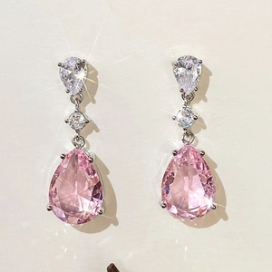 Detailed view of pink pear-cut zircon earrings with shimmering crystal accents