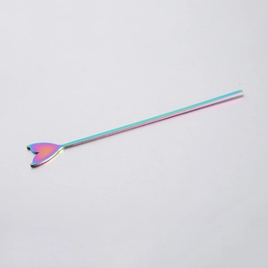 Macro shot of iridescent rainbow stainless steel cocktail stirrer with mermaid tail design