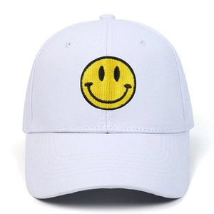 Close-up of high-quality yellow sad face embroidery on a white cotton baseball cap