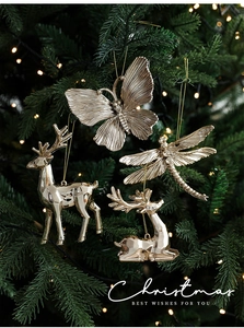 Primo piano di decorazioni natalizie dorate con cervi e libellule su un albero festivo