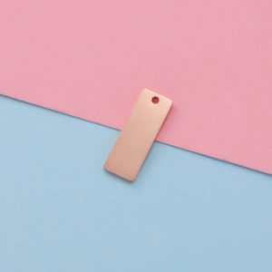 Detailed close-up of rose gold rectangular metal pendant with smooth mirror finish and hole