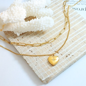 Collana a doppio strato in titanio dorato con catena a graffetta e pendente cuore