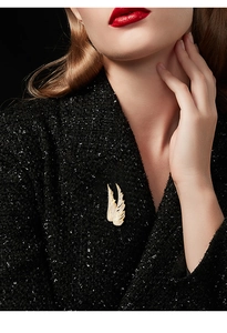 Golden wing brooch with zircon inlay pinned on black sequin blazer for elegant styling