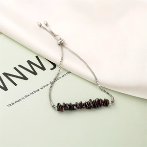Detailed view of adjustable stainless steel bracelet with dark red gemstone chips