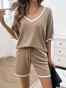 Detail of khaki knit two-piece set featuring V-neck top with white trim and drawstring shorts