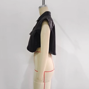 Side view of faux leather sleeveless vest featuring a sharp lapel and tailored crop cut