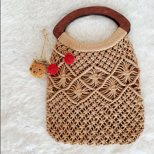 Handmade crochet tote bag with wooden handles and bohemian pineapple charm detail