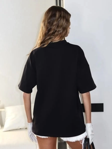 Πίσω όψη ενός φαρδιού μαύρου streetwear T-shirt με σχέδιο χαμηλωμένου ώμου σε μοντέλο