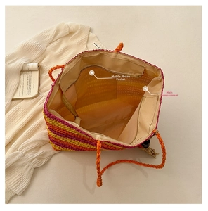 Internal view of colorful straw tote bag showing phone pocket and main compartment