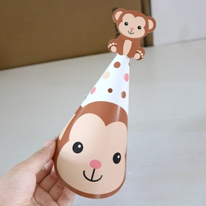 Detail of a paper jungle party hat with a cute 3D monkey design and colorful polka dots