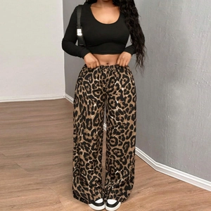 Dettaglio di pantaloni larghi con stampa leopardata e crop top a maniche lunghe