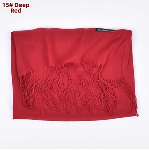 Detail of dark red faux cashmere scarf with fringes and soft woven texture