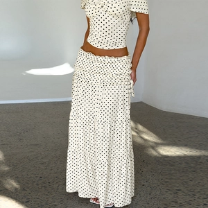 Detail of a chic cream polka dot maxi skirt featuring layered ruffles and flowy fabric