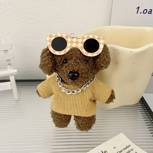 Dettaglio del portachiavi a forma di cane di peluche con maglione giallo e occhiali a scacchi