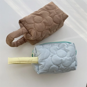 Close-up of floral quilted cosmetic bags in brown and blue with soft padded texture