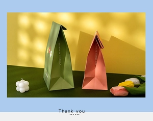 Detail of pink and green matte gift bags with motivational quotes in a stylish setting