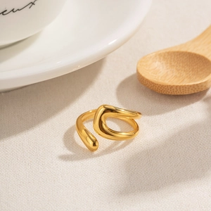 Classic gold hollow irregular ring for women with minimalist fluid lines on white fabric