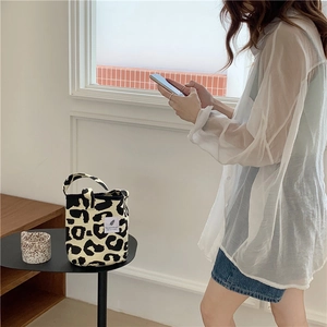 Close-up of leopard print canvas tote bag featuring a white decorative textile label