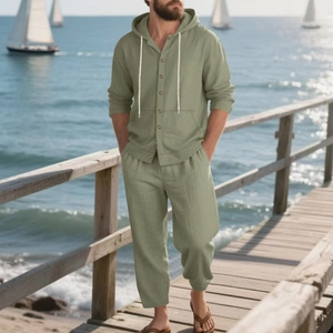 Close-up of men's linen beach set in sage green with button detail on wooden pier