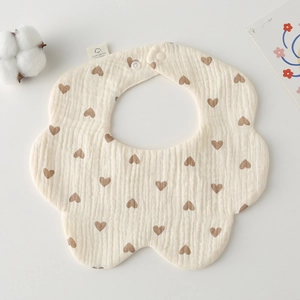 Macro view of petal-shaped cotton gauze baby bib with brown heart print and snap button