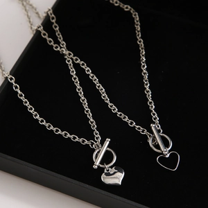 Detail of silver heart pendants with toggle clasp on black velvet jewelry box