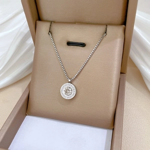 Macro shot of titanium steel necklace pendant with a central round cut zircon and pavé detail
