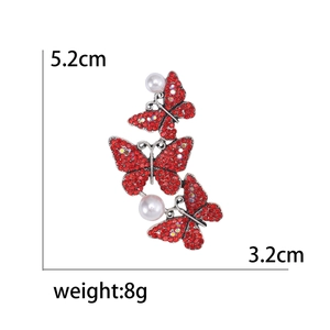 Vintage butterfly brooch with red rhinestones and white pearls, sized 5.2cm by 3.2cm