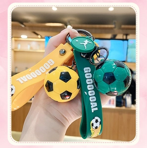 Dettaglio di portachiavi da calcio gialli e verdi con cinturini in silicone GOOOOOAL