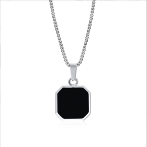 Detailed view of square stainless steel pendant with black drip oil on a box chain