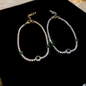 Vue macro de bracelets en cristal avec pierres d'émeraude sur fond de velours noir