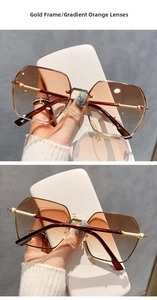 Detailed close-up of rimless gold frames with gradual orange tinted sunglass lenses