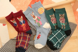 Detailed view of three pairs of patterned cotton socks in red, blue, and forest green colors