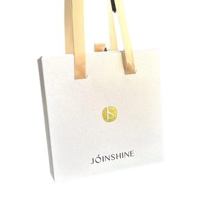 Sac cadeau bijoux blanc élégant avec poignées en soie champagne et logo JS doré