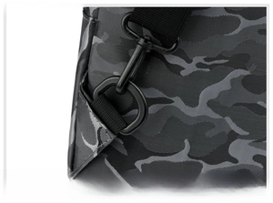 Détail du crochet métallique robuste et du tissu camouflage sur la bandoulière du sac