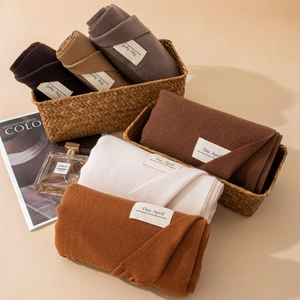 Sciarpe effetto cashmere in toni della terra con nappe ed etichette tessute minimaliste