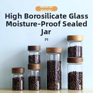 Vertical glass storage jars with wooden lids showcasing coffee beans in four sizes