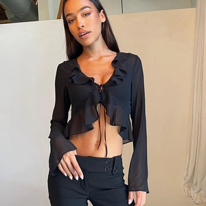 Detail of black ruffle chiffon top with deep V-neckline and tie-front long sleeves