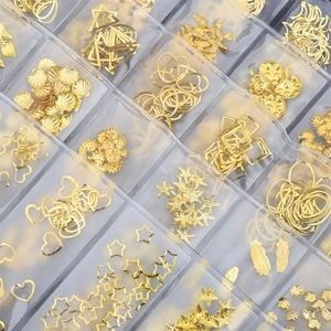 Close-up of golden metal star and heart charms for DIY jewelry and nail art crafts