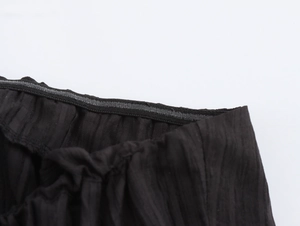 Detailansicht des elastischen Bundes mit Faltenstruktur am schwarzen trägerlosen Kleid
