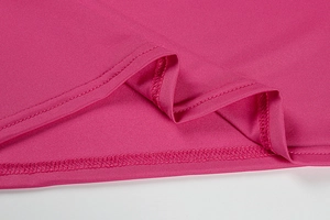 Detail of rose pink dress showing fine double-needle stitching and fabric texture